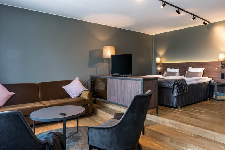 Living room area and beds in a Junior Suite at Scandic Infra City in Stockholm