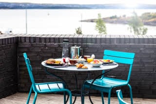 Utendørs oppdekket frokostbord med utsikt over vannet