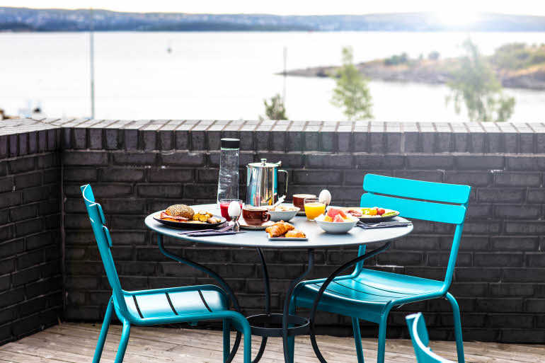 Utendørs oppdekket frokostbord med utsikt over vannet